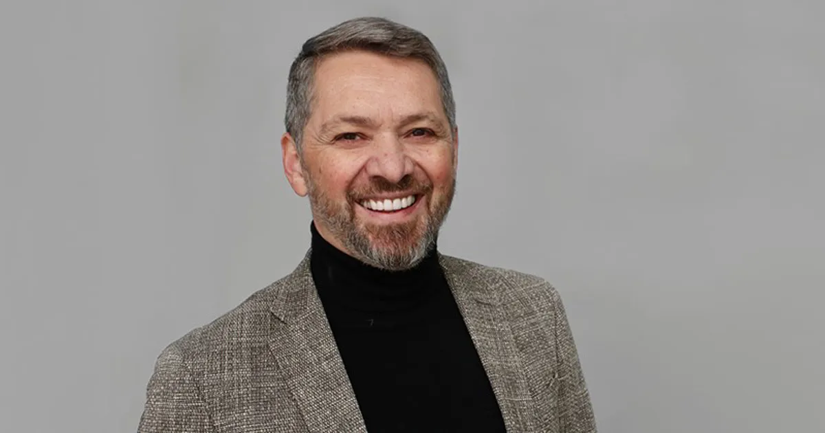 Man ler stort och tittar in i kameran.