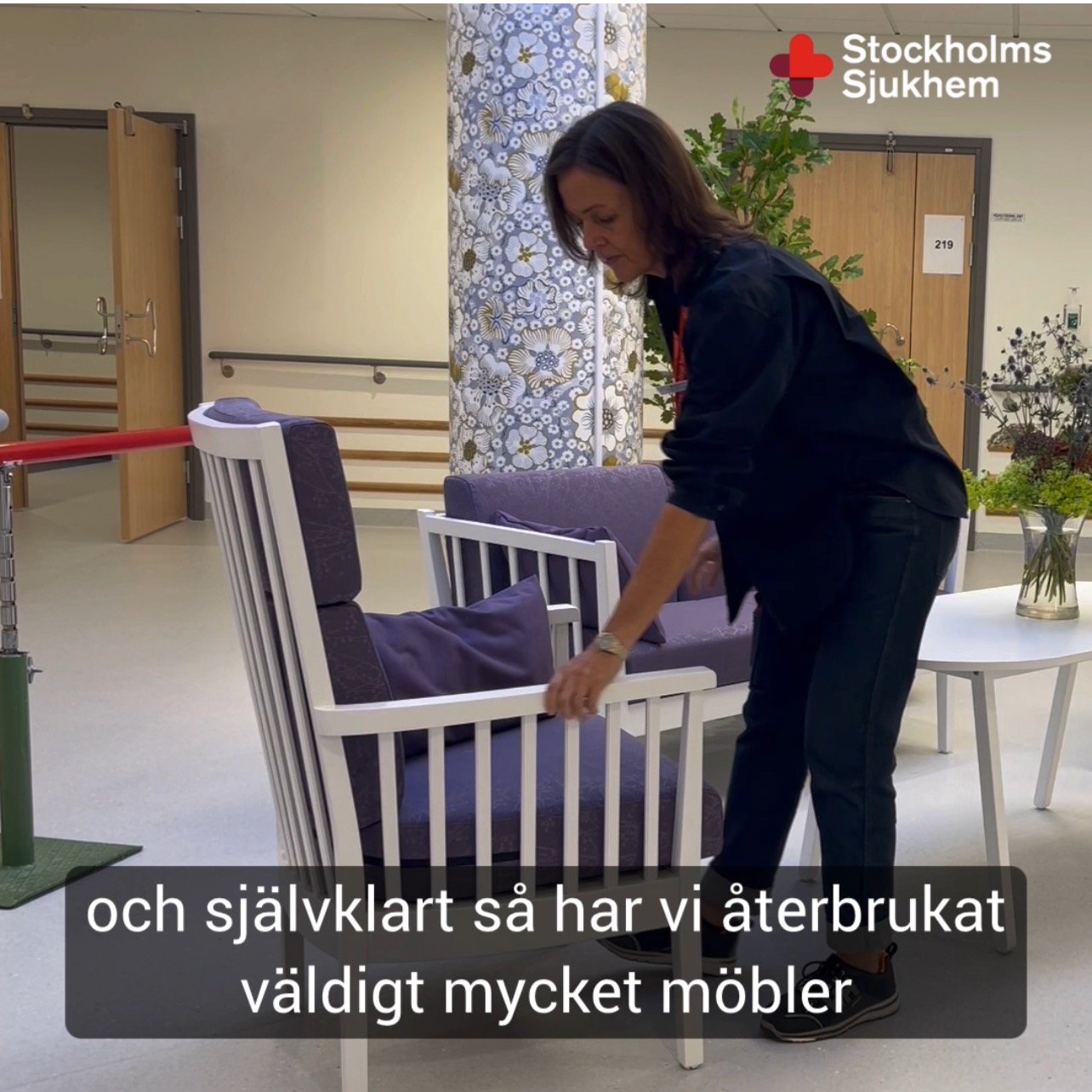 Kvinna arrangerar lila fåtölj på ett äldreboende. Text: "och självklart så har vi återbrukat väldigt mycket möbler".