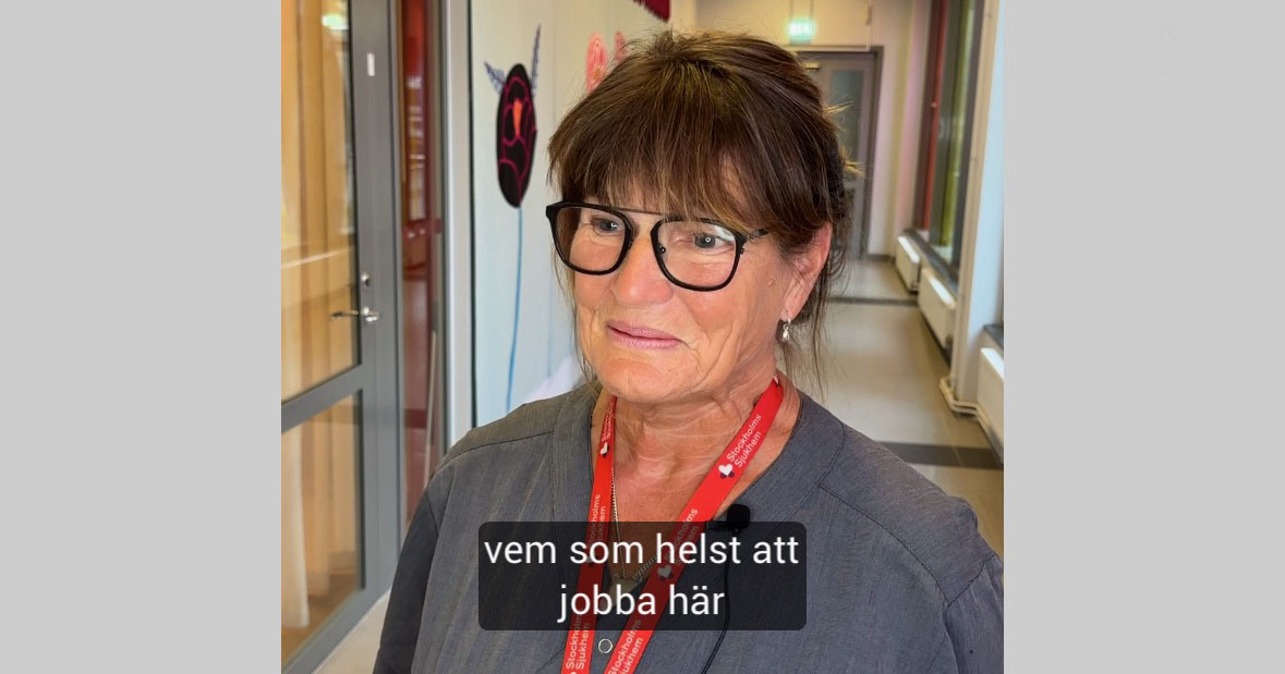 Kvinna med glasögon och röd namnskylt står i en korridor, text: "vem som helst att jobba här".