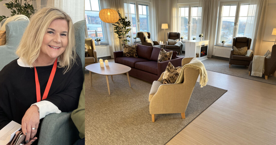 Leende kvinna i fåtölj till vänster, mysigt vardagsrum med soffor och fönster i bakgrunden.