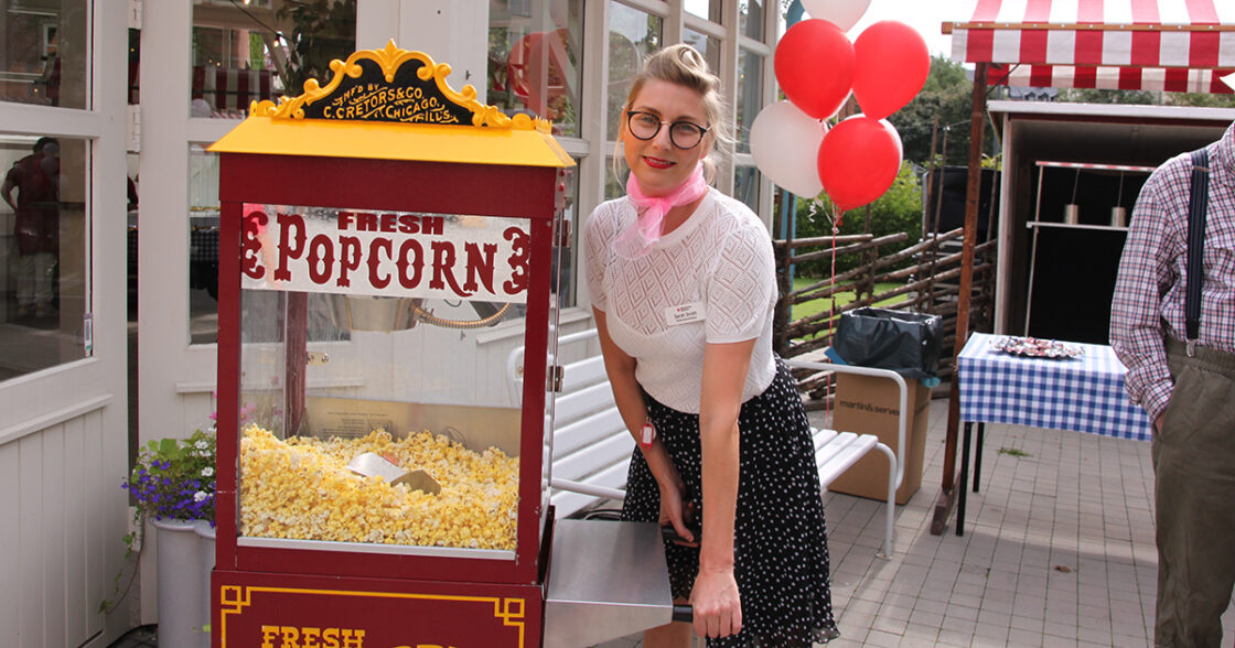 Nyhetsbild, popcornmaskin och glad medarbetare.