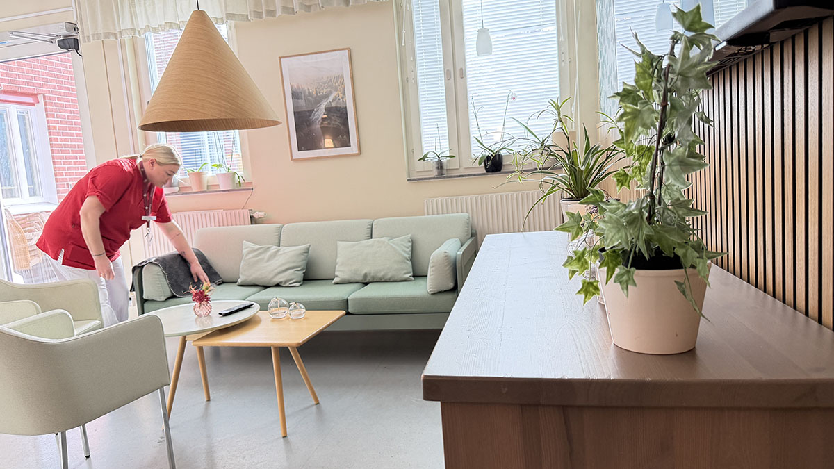 Nyhetsbild, medarbetare ordar kudde i soffgrupp.
