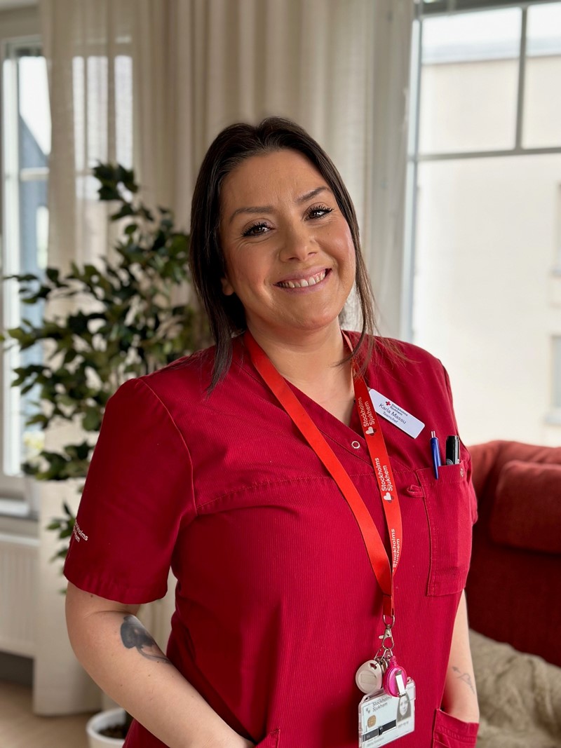 Karla, en tjej i arbetskläder som ler mot kameran. Hon är teamchef.