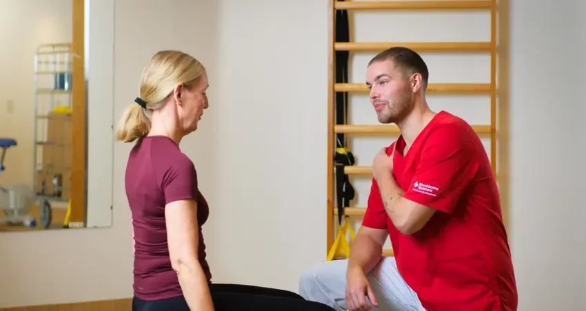 Medarbetare instruerar patient. Rehab.