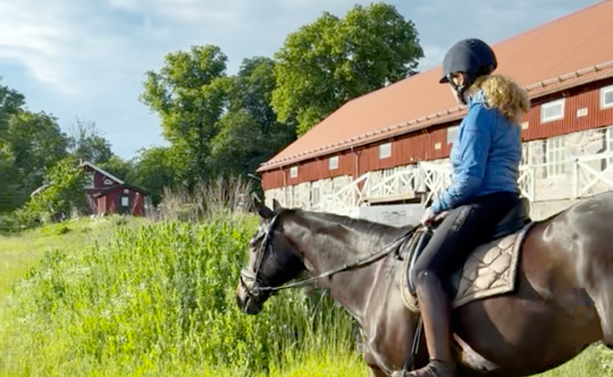 Kvinna som rider på häst
