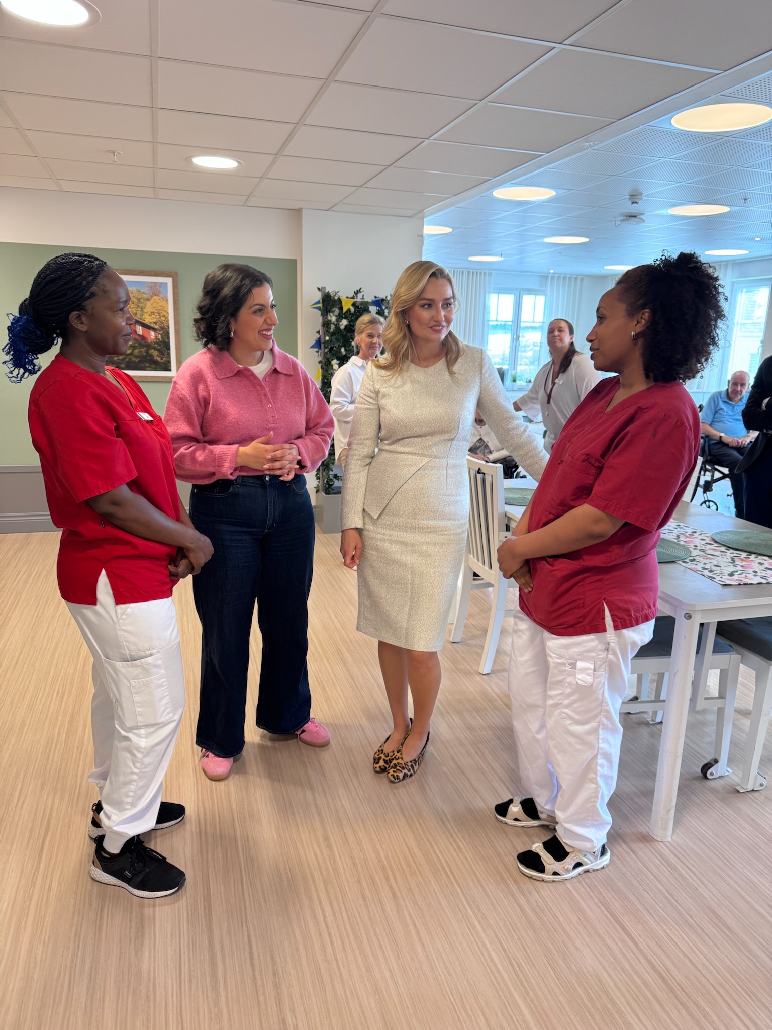 Näringsminister Ebba Busch och utbildningsminister Simona Mohamsson samtalar med medarbetare på äldreboendet Nyckelharpan.